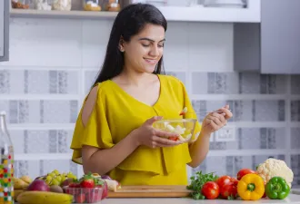 Woman cutting fresh vegetables at home